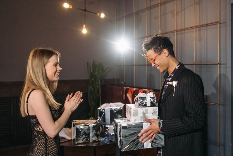 Friends exchanging Christmas gifts indoors with joy and festive atmosphere.